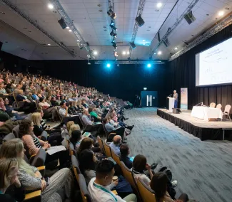 An auditorium full of people listening to a speaker at the CCLG Annual Conference