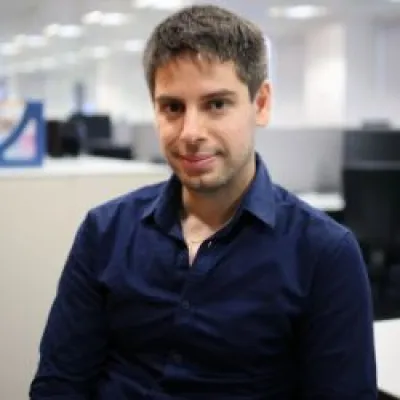 Antonios smiling at the camera with short dark hair, wearing a navy blue shirt.