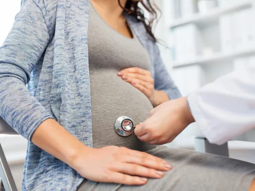 Pregnant woman with stethoscope on belly