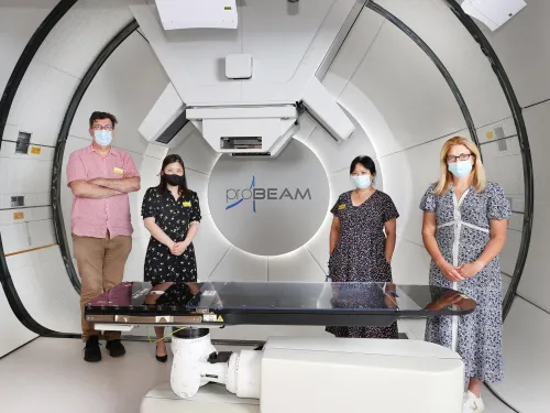 The research team stood in a specially designed proton beam therapy suite.