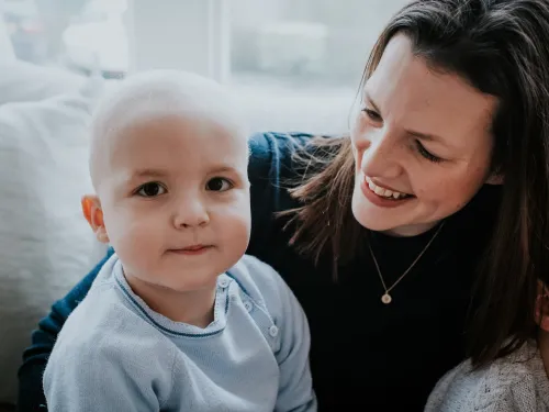 Kate, a woman with dark hair, smiling at her son Sebby, who is a toddler.