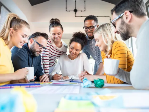 A group of people around a table, collaborating on notes.