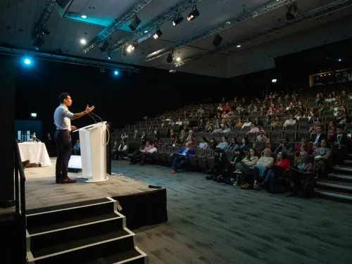 A man presenting in an auditorium.