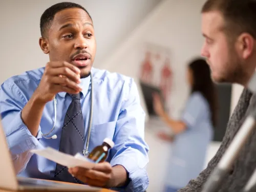 A doctor explaining something to a young man.