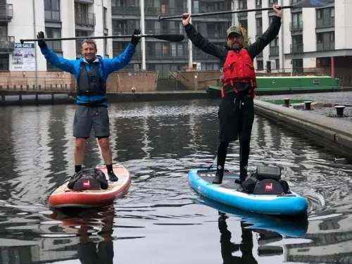 Two men on paddleboards during fundraising challenge