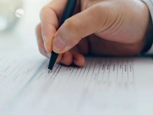 hand with pen filling in form