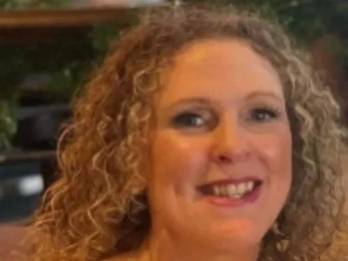 A woman with brown curly hair smiling